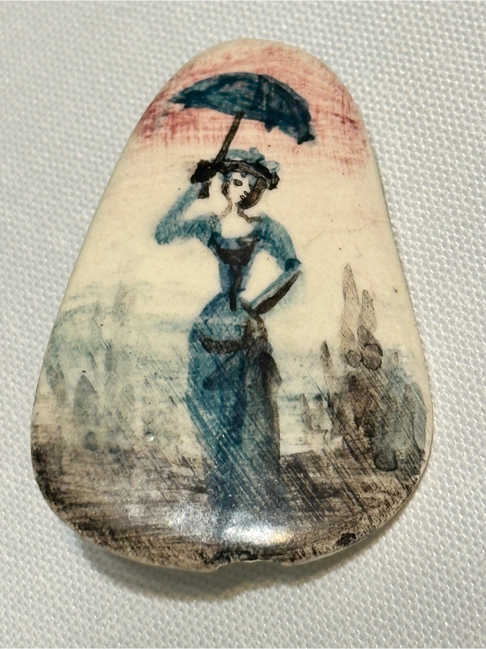 Small, hand-painted miniature artwork on a smooth stone or ceramic cabochon